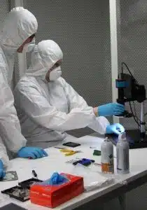 Data recovery engineers examining hard drive heads in cleanroom