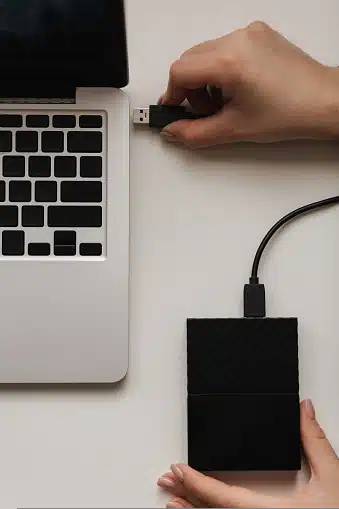 hand connecting portable hard drive to laptop for data transfer at Payam Data Recovery, Australia.
