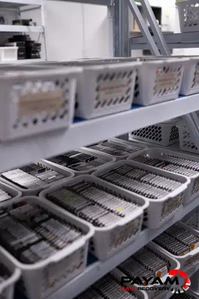 White bins full of small hard drives viewed from above in the donor parts room