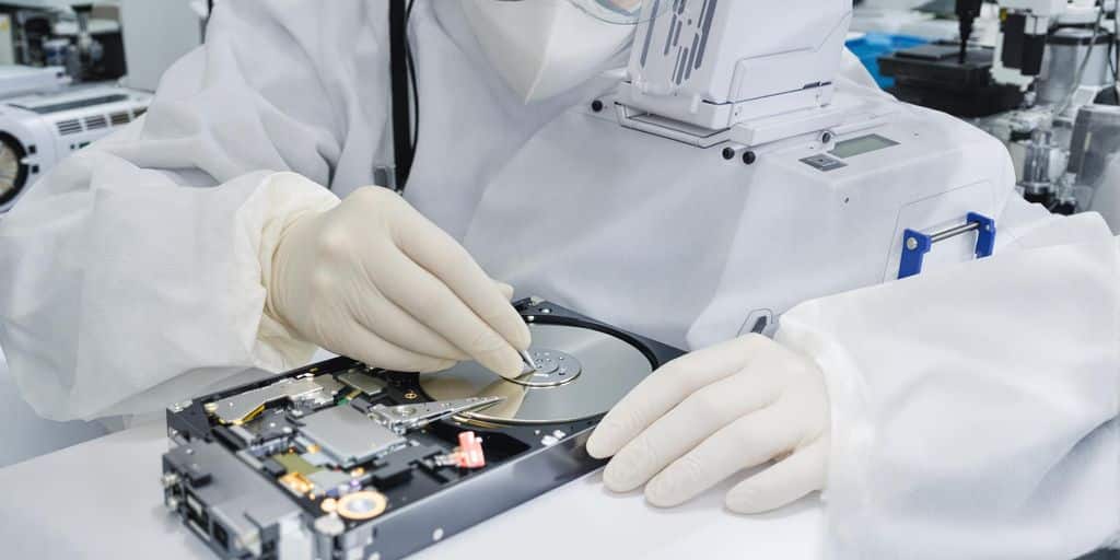 Technician repairing hard drive in clean dust-free lab