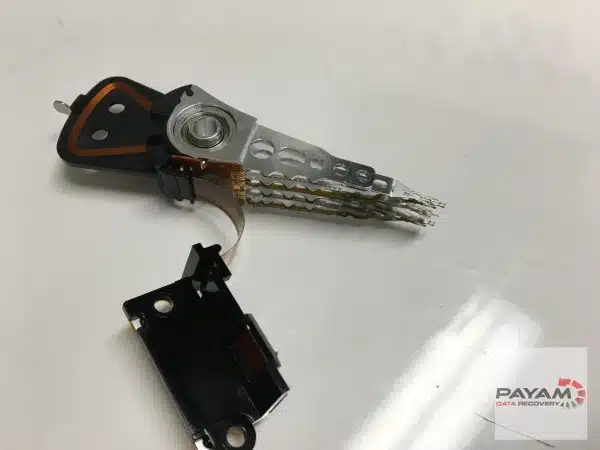 Hard drive head stack assembly removed from the drive, on a white surface