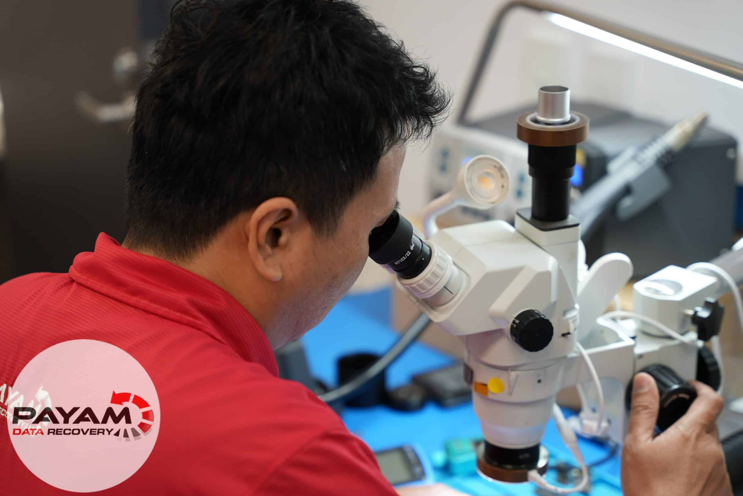Technician using microscope for electronic repair at Payam Data Recovery, Australia.