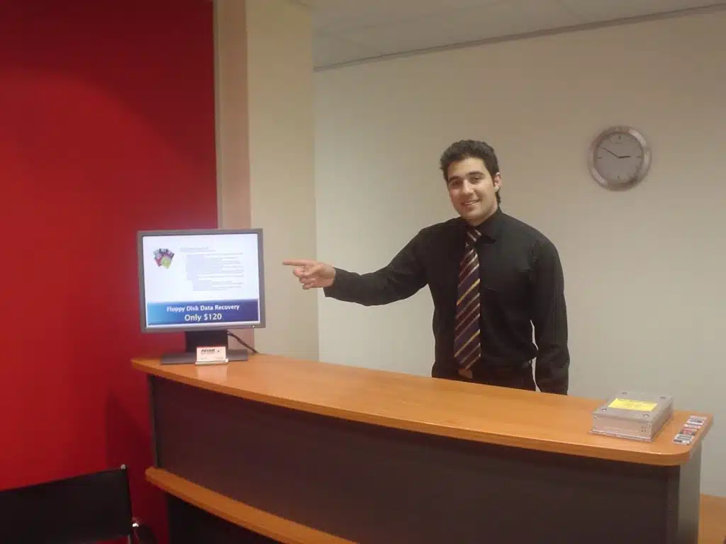 Payam Toloo at a reception desk in the early years of Payam Data Recovery