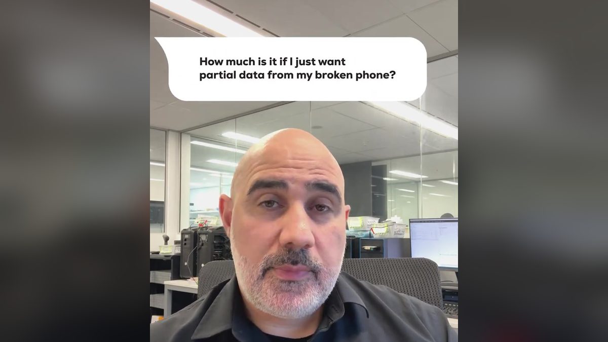 Video still: presenter at an office desk with an on screen question about the cost of partial data from a broken phone