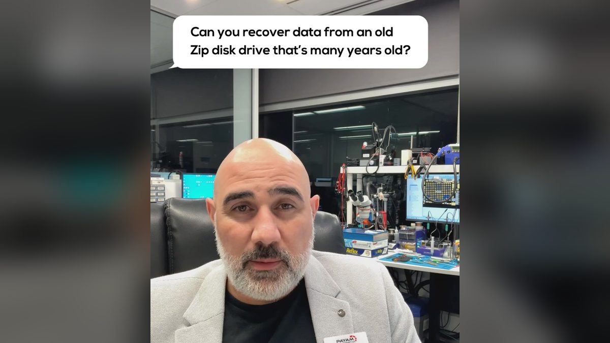 Video still: presenter in the lab with an on screen question about an old Zip disk drive
